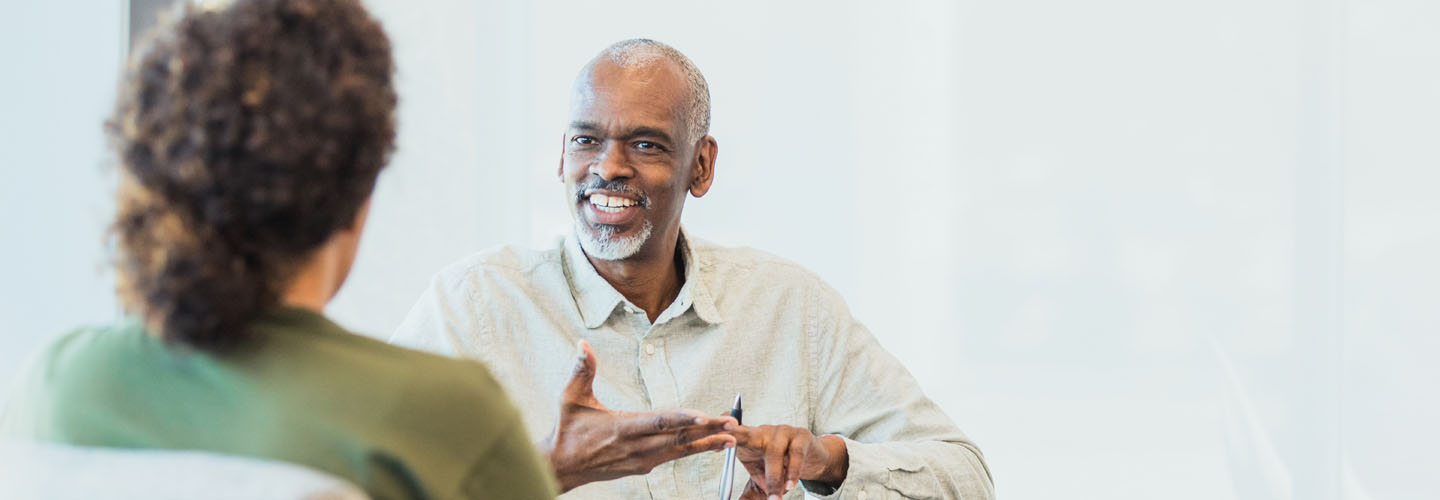 Man speaking with woman across table